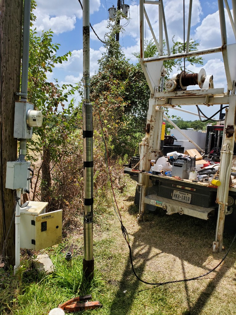 Submersible pump being installed into a well casing